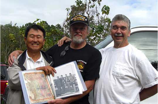 image of veterans holding a picture of themselves in Vietnam